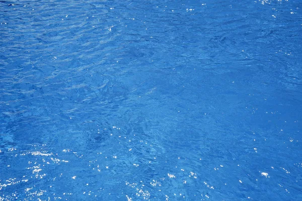 Agua azul en la piscina con reflejos solares —  Fotos de Stock
