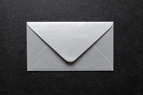 Серебряные конверты на черном фоне — стоковое фото