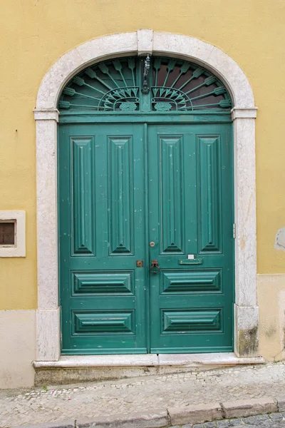 Elegant green wooden door in yellow wall — Stock Photo, Image