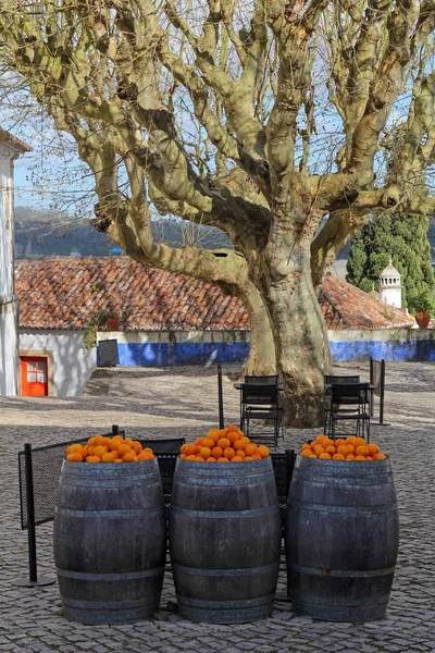 heap of oranges on the top of wooden barrels in Obidos, Portugal