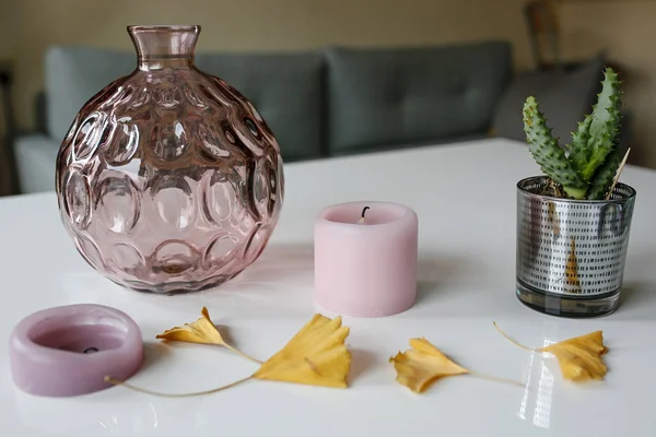 Florero, velas, hojas de ginkgo, flor de cactus sobre una mesa blanca brillante —  Fotos de Stock