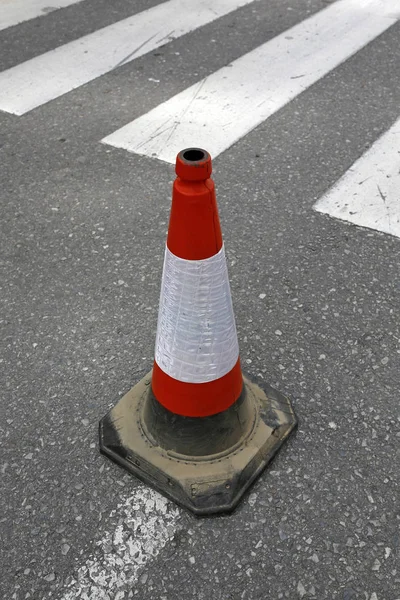 Cono di traffico sull'asfalto vicino a zebra — Foto Stock