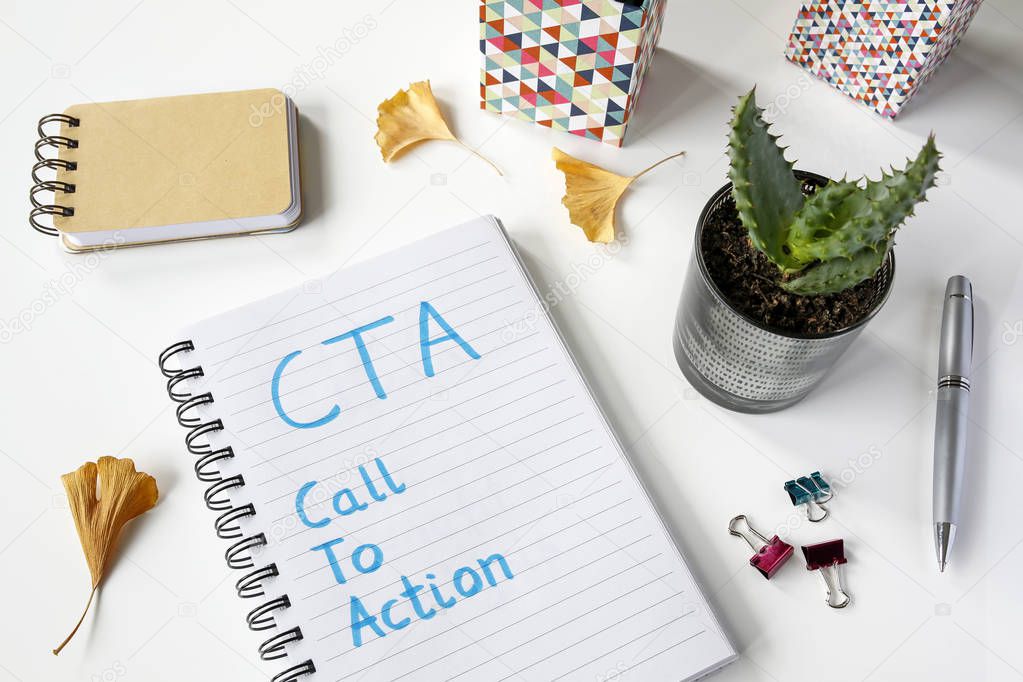 CTA- Call To Action written in notebook on white table