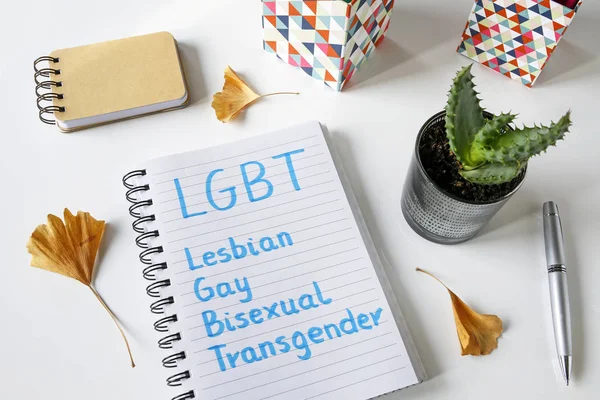 LGBT (Lesbianas, Gays, Bisexuales, Transgénero) escrito en cuaderno sobre mesa blanca — Foto de Stock