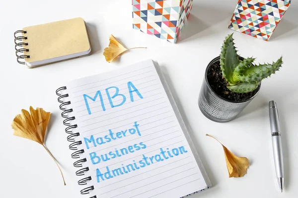 Mba-Diplom-Betriebswirt in Notizbuch auf weißem Tisch geschrieben — Stockfoto