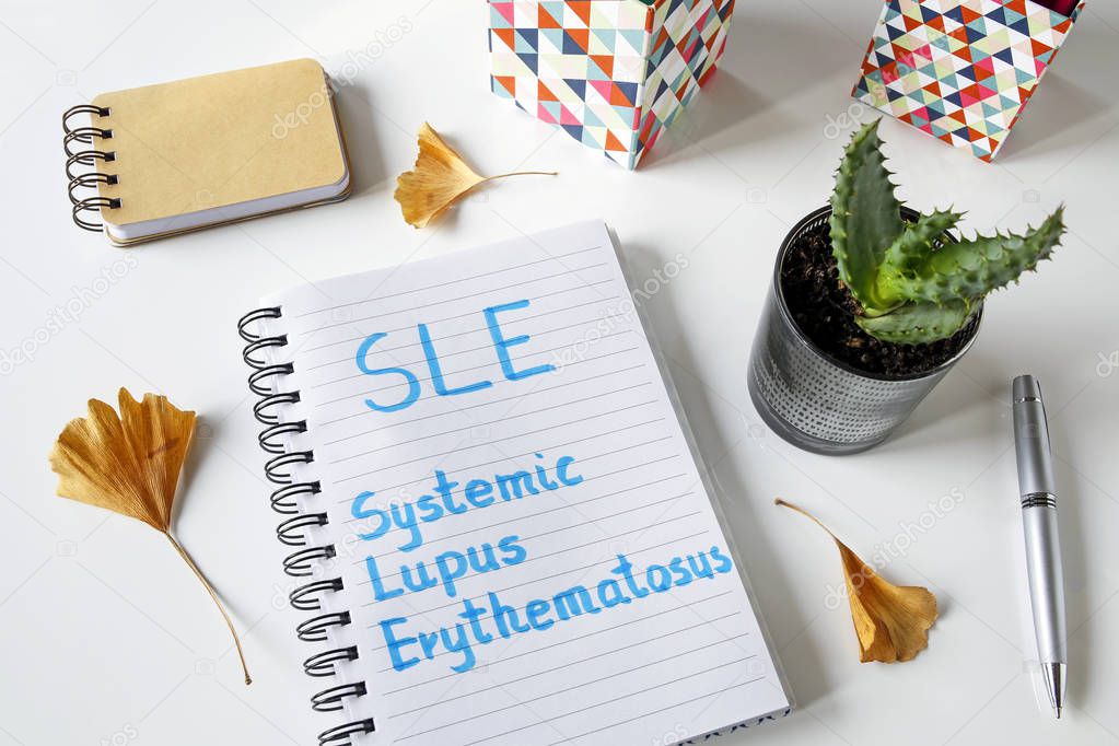 SLE Systemic Lupus Erythematosus written in notebook on white table