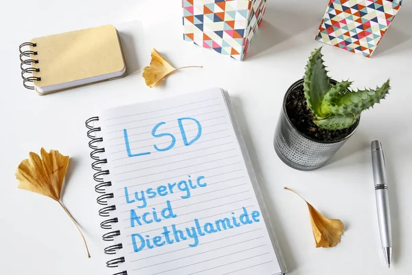 LSD Acido Lisergico Dietilammide scritto in un taccuino su tavolo bianco — Foto Stock