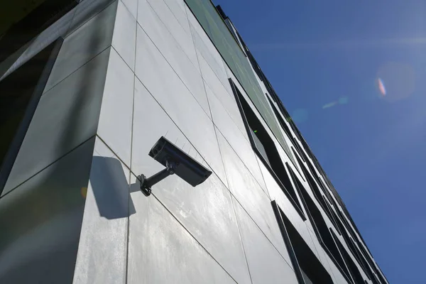 Cámara de seguridad en edificio moderno con destellos de sol — Foto de Stock