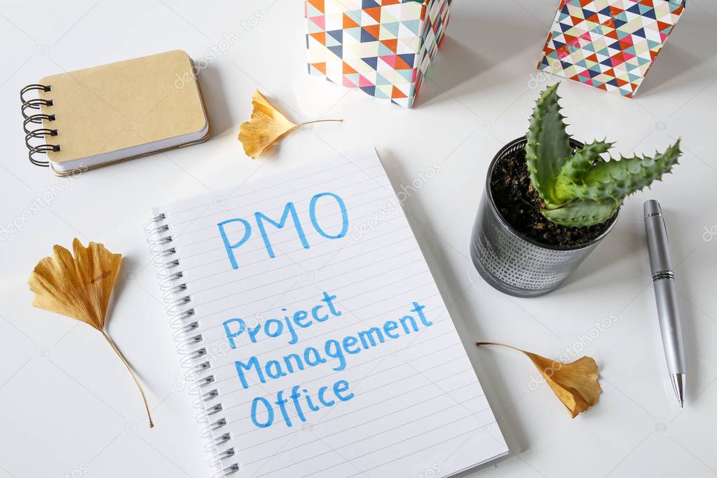 PMO Project Management Office written in notebook on white table