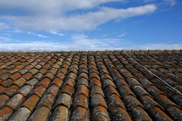 Старая глиняная черепица крыша против голубого неба — стоковое фото