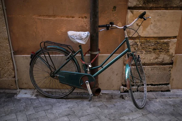 Bicicleta rústica velha na frente da parede de pedra velha — Fotografia de Stock