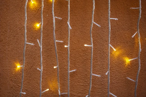 Luces de Navidad en pared de piedra naranja —  Fotos de Stock