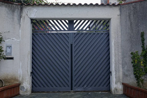 Grijze toegangspoort in stenen muur — Stockfoto