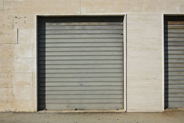 Porta de garagem de metal na parede de mármore — Fotografia de Stock
