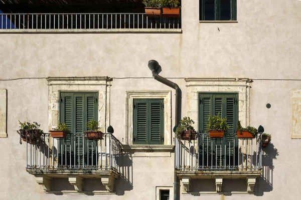 Gevel van typisch Italiaans gebouw, balkon versierd met bloemen — Stockfoto