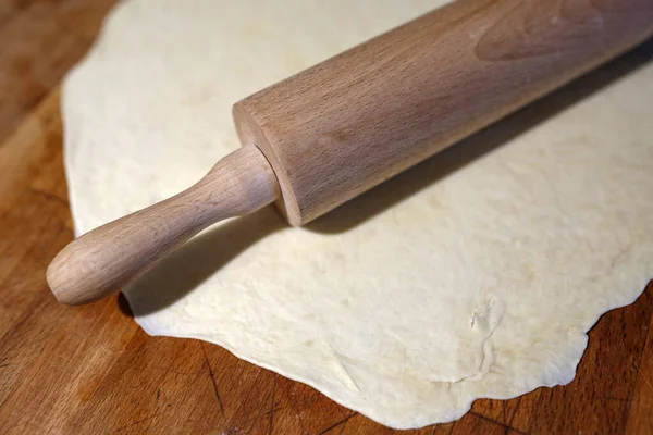 rolled out dough and rolling pin on the board