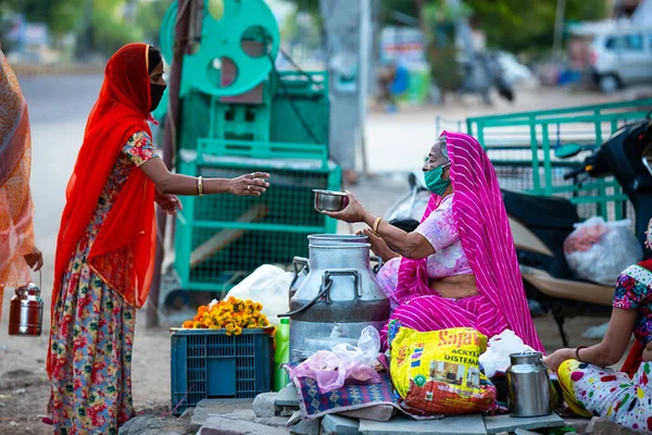 Jodhpur, Rajashtbn, Hindistan. 30 Mart 2020 'de koruyucu maske takan insanlar Hindistan' da Coronavirus, COVID-19 salgını nedeniyle yiyecek satın alıyorlar..