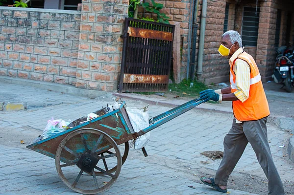Jodhpur, Rajashtbn, Hindistan. 30 Mart 2020: Hintli bir adam maske takıyor çöp arabasıyla şehir yollarını temizliyor, Coronavirus, Covid-19 salgını, Swachh Bharat Misyonu.