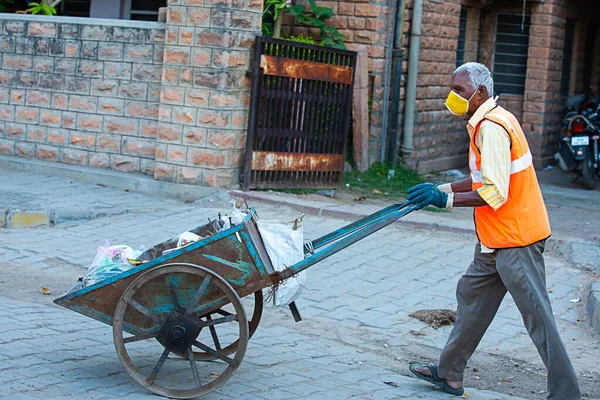 Jodhpur, Rajashtbn, Hindistan. 30 Mart 2020: Hintli bir adam maske takıyor çöp arabasıyla şehir yollarını temizliyor, Coronavirus, Covid-19 salgını, Swachh Bharat Misyonu.