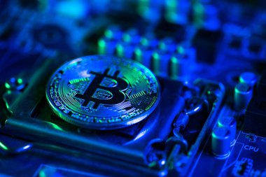 Gerçek elektronik bilgisayar anakartında Bitcoin Kripto para birimi. Koyu Mavi Tonu teknoloji sektörü kavramının finansmanı olarak kullanın.