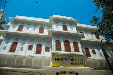 Pushkar, RAJASTHAN, INDIA - 6 Ekim 2019: Mavi gökyüzüne karşı birçok ahşap kapı ve pencereli geleneksel ev mimarisi, mimari konsept.