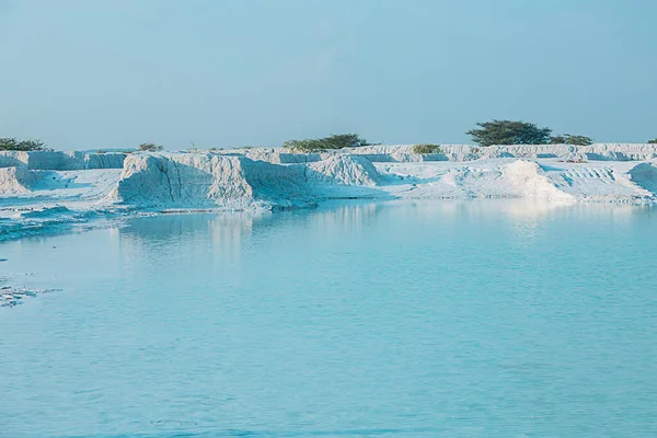 white marble dumping yard with beautiful water lake with blue reflection and clear sky travel background.