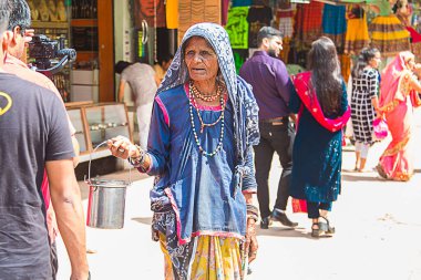 Delhi, Hindistan - 18 Haziran 2019: Yaşlı Hintli yardıma muhtaç kadın yiyecek ve para dileniyor, milyarlarca insan hala yoksulluk sınırı altında yaşıyor.