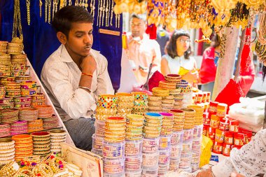 MUMBAI, INDIA, 10 EKİM 2019: Sokak dükkanında renkli bilezikler satan kimliği belirsiz bir sokak satıcısı.