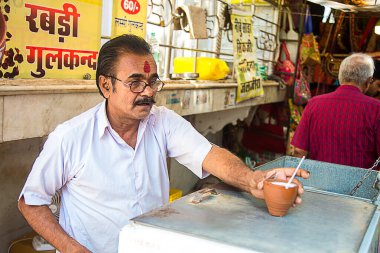 Mumbai, Rajasthan, Hindistan - 18 Haziran 2019: Hindistan yerel sokak pazarında kilden yapılmış bir bardak Lassi veya milk shake satıyor. Yaz içeceği.