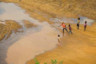 Jaisalmer, Rajasthan, Hindistan - 18 Haziran 2019: Çölden arta kalan suyu, su kıtlığını, kuraklığı ve kriz ortamını arayan çocuklar.
