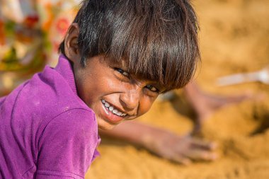 Jodhpur, Rajasthan, Hindistan - 18 Haziran 2019: Kameraya gülümseyen fakir kırsal çocuk, yoksulluk imtiyazsız Hintli çocuklar.