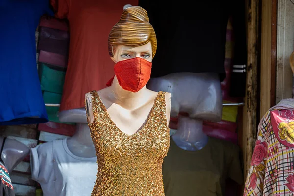 Yüzünde maske olan kadın manken. Mağazalar, covid-19 salgınından dolayı kısıtlamalardan sonra yeniden açılıyor. Birkaç güvenlik önlemiyle normal hayata geri dönüyorlar..