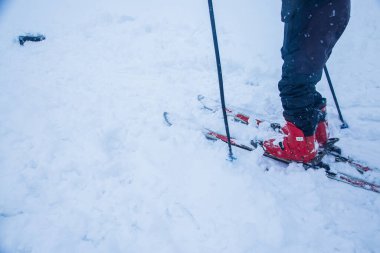 Karlı bir günde kayak yapan bir adam, saf beyaz arka planda izole edilmiş kayak ekipmanları, maceralı bir aktivite -