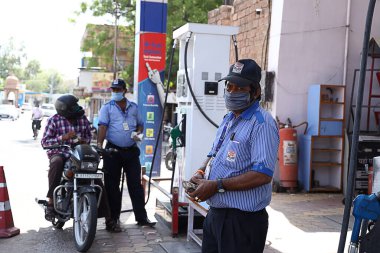 Jodhpur, Rajasthan, Hindistan - 20 Mayıs 2020: Benzin istasyonunda benzin dolduran maske takan işçiler, Covid-19 salgınından kaynaklanan kısıtlamalar sonrası şehir yeniden açıldı, normal hayata geri döndü.