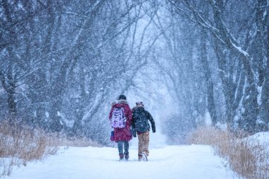 Kar yağarken okuldan sonra eve gidiyorum.