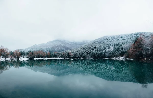 Landscape  lake Turquoise, Crimea  - with snow-capped mountains reflecting in the surface of the calm lake, winter\'s day from the lake shore