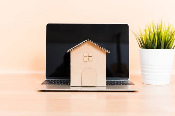Cardboard paper model house and computer laptop — Stock Photo, Image