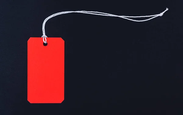 Красная бирка на чёрном фоне — стоковое фото