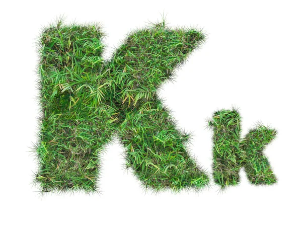 Letra K na grama verde isolada — Fotografia de Stock
