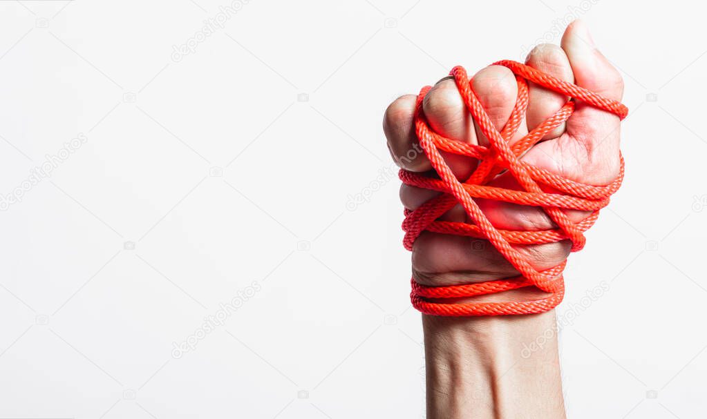 Red Rope on fist hand on white background, Human rights day conc