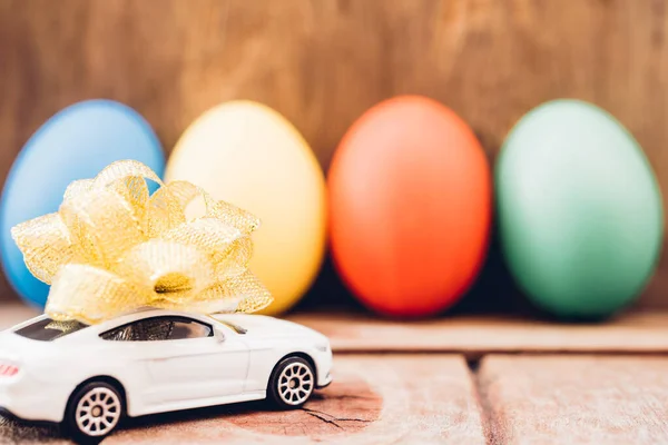 Easter egg and toy car on wooden background, — Stock Photo, Image