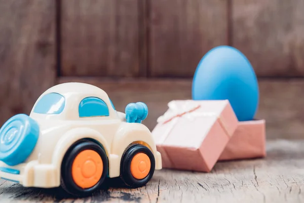 Huevo de Pascua y coche de juguete sobre fondo de madera —  Fotos de Stock
