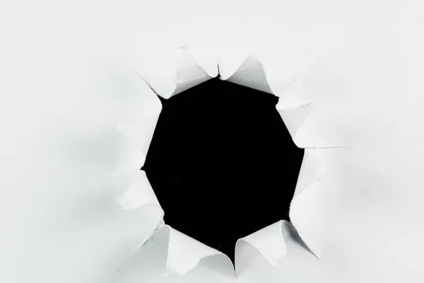Genombrott rivet stort svart hål i vitt papper — Stockfoto