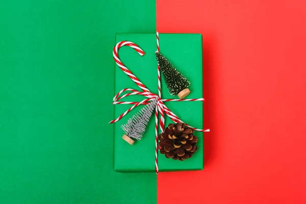 New Year, Christmas Xmas holiday composition, Top view gift green box, clews of rope, green fir tree branch on red and green background with copy space