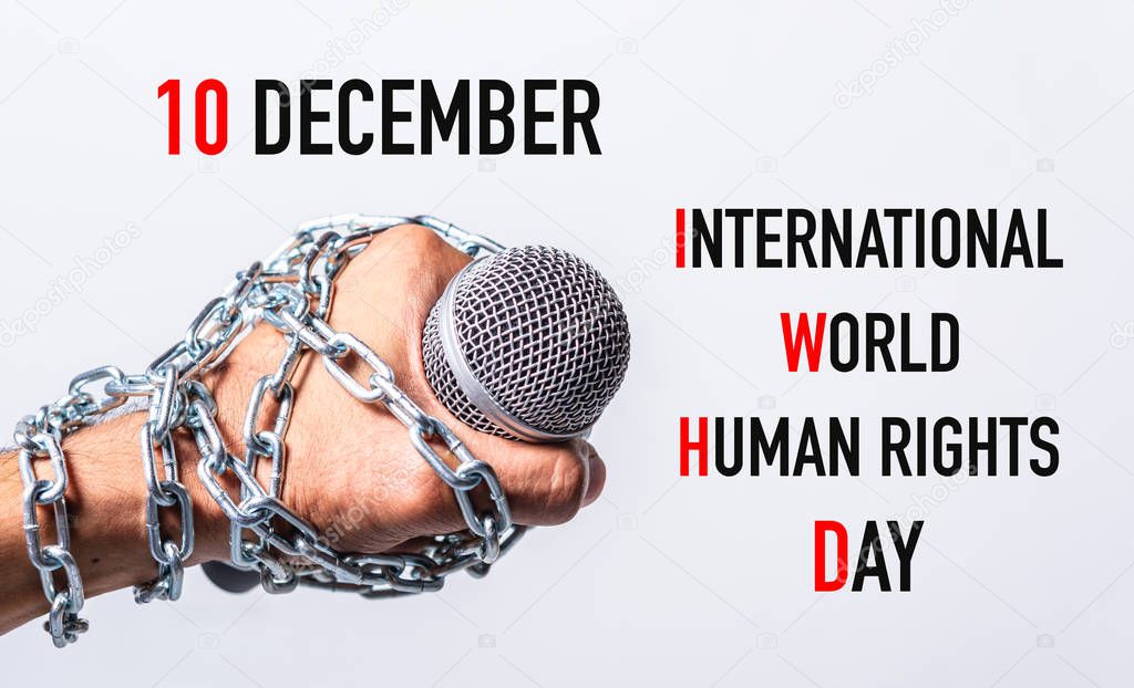Hand holding microphone and have chain on fist hand with 10 december international world HUMAN RIGHTS DAY text on white background, Human rights day concept