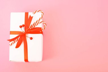 Mutlu yıllar ve Noel günleri, üstteki düz görünüm kompozisyon hediye kutusu pembe zemin üzerinde metin alanınız için fotokopi alanı ile birlikte.