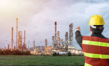 Petrol rafinerisi yapı petrokimya endüstrisinde duran beyaz kasklı Petrokimya mühendisi.