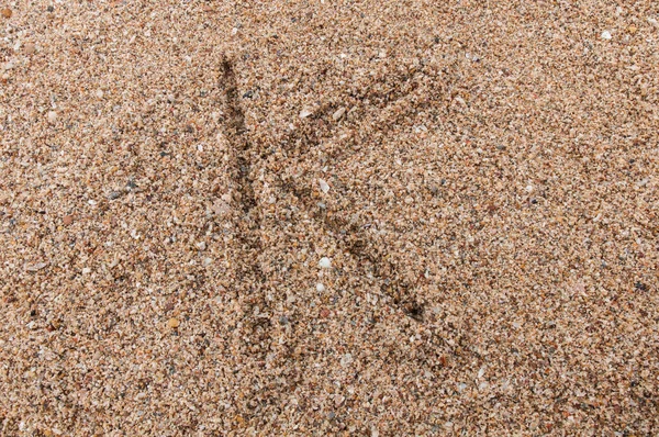 砂の上に書かれたアルファベットのK文字 — ストック写真