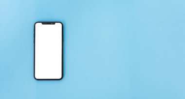 Modern teknolojinin üst görünümü. Akıllı telefon, mavi arka planda, kopyalama alanı ile birlikte.