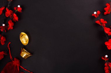 Çin Yeni Yılı, düz üst görünüm, altın külçe ve Çin Çiçeği siyah zemin üzerinde metin alanınız için fotokopi alanı